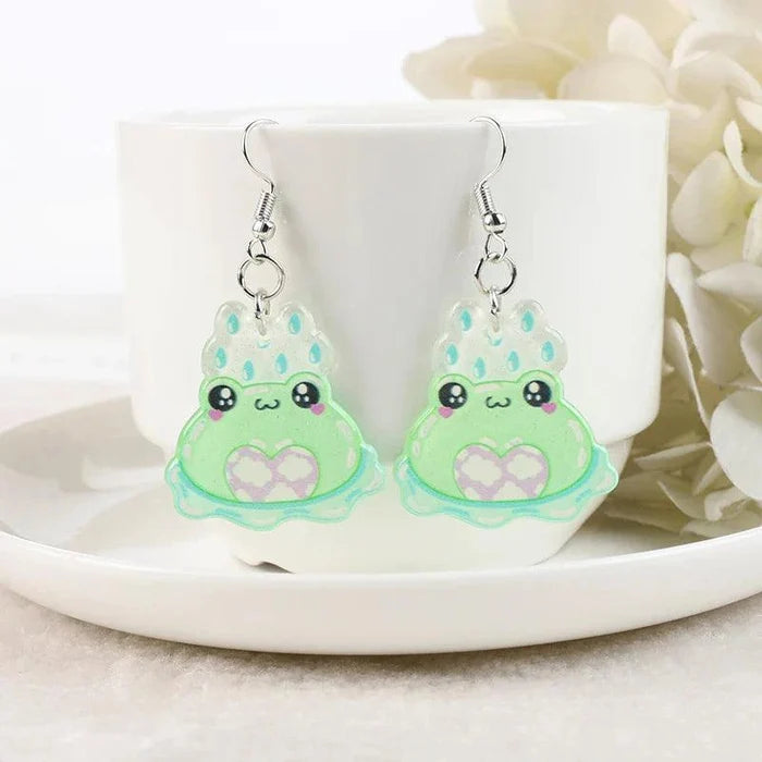 Light green frog face acrylic dangle earrings with pale blue raindrop accents