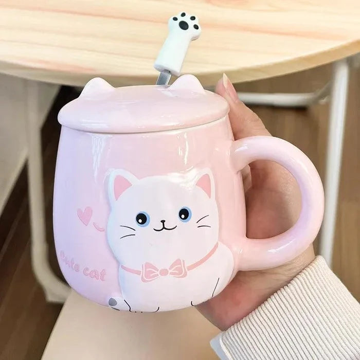 Pink cat face mug with lid and heart details, held in a hand