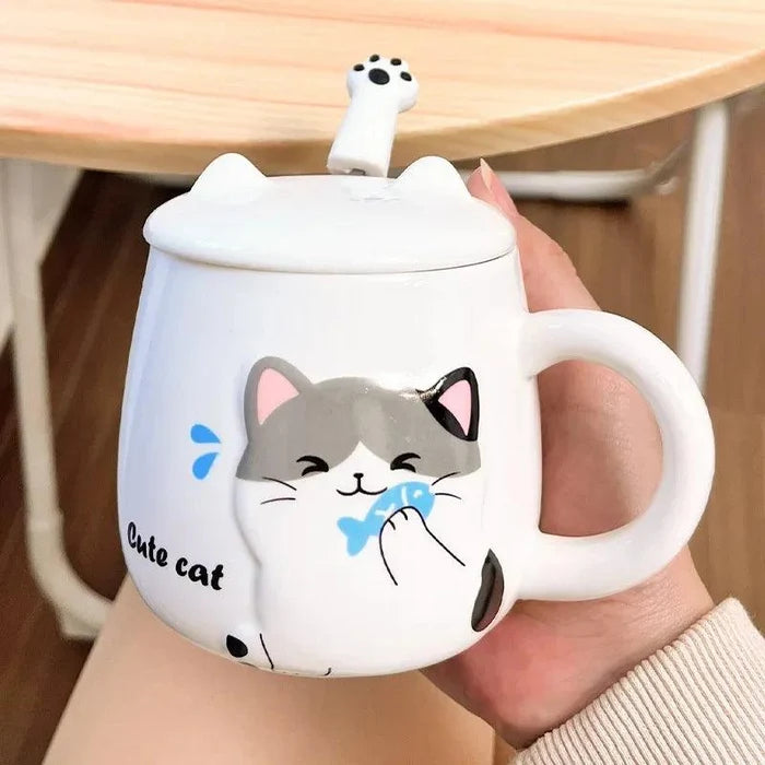 White cat face mug with lid, held in a hand