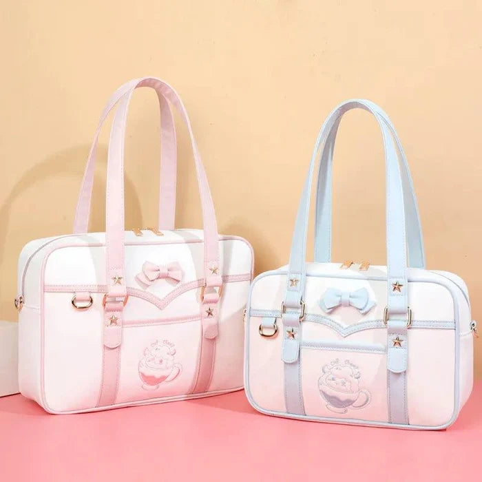 Pink-and-white messenger bag with bow, star accents, top handles, and shoulder strap