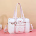 Pink-and-white messenger bag with bow front panel, star accents, and side shoulder strap