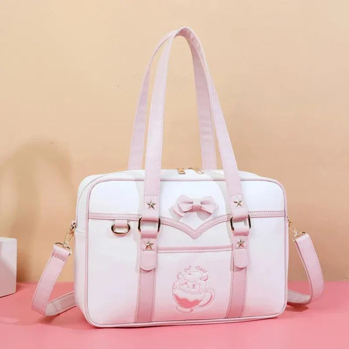 Pink-and-white messenger bag with bow front panel, star accents, and side shoulder strap