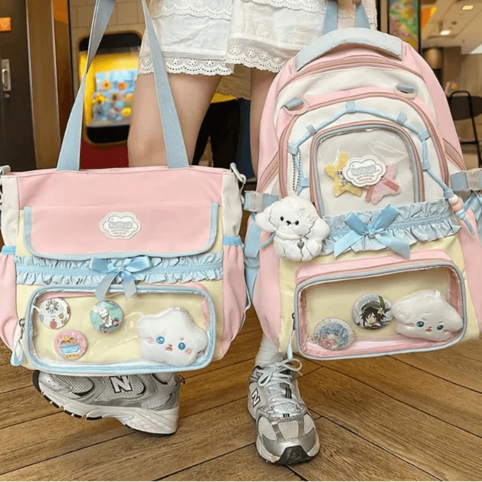 Pastel backpack with front charms and bow accents; matching pink tote bag with ruffle trim.