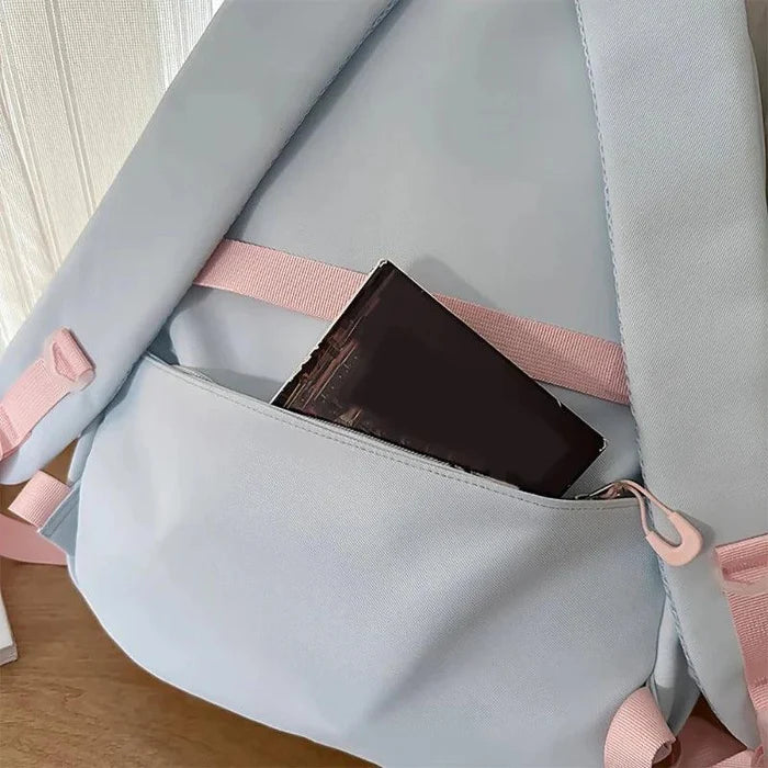 Pastel backpack side pocket interior with pink lining holding a dark case.