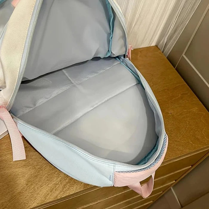 Pastel backpack with open main compartment and light gray interior lining.