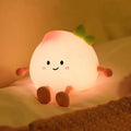 Peach-shaped night light with cute face and green sprout, glowing softly