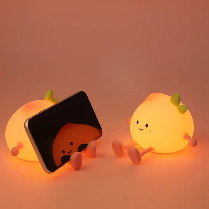 Peach night light with smiling face and green sprout, glowing next to a cover