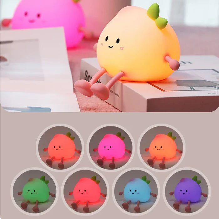 Peach-shaped night light with smiling face and green sprout, glowing on a book