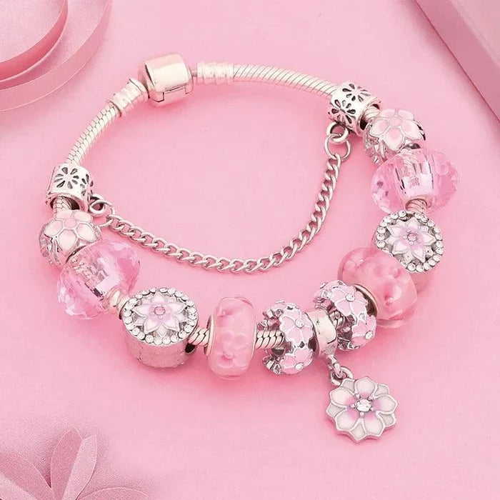 Silver charm bracelet with pink bead charms and flower pendant; snap clasp