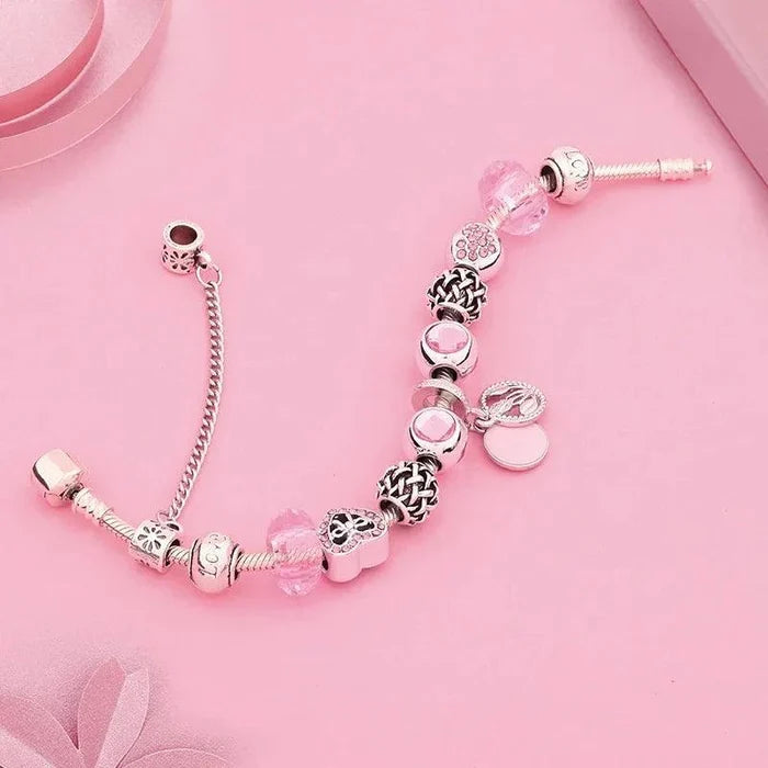Pink charm bracelet with silver-tone beads and heart-and-flower charms on a short chain