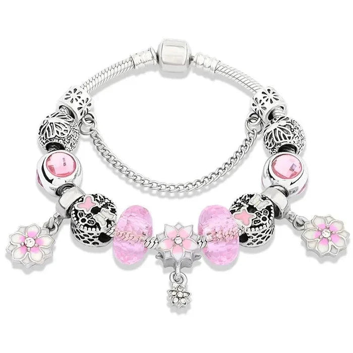 Silver charm bracelet with pink beads, heart charms, and small hanging flower charm