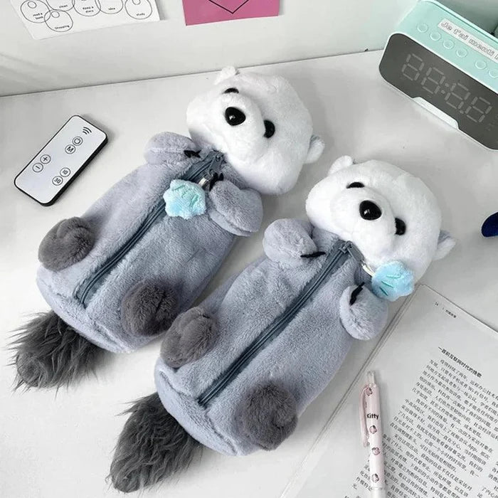 Gray and white plush otter pencil case with front zipper and small blue charm