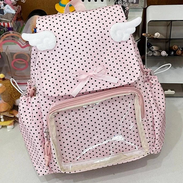 Pink polka dot backpack with bunny-ear accents, front clear pouch, and ribbon bow