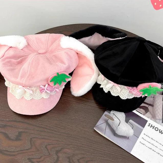 Pink and black strawberry bunny hats side by side with lace ruffle bands and ear flaps
