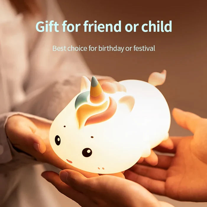White unicorn night light in cupped hands, bright warm face light