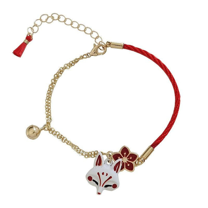 Fox head charm bracelet with gold chain, red cord band, lobster clasp, flat lay