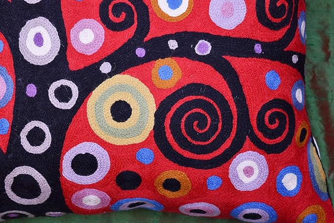 Close-up of red, blue, and purple circular pattern on a dark decorative pillow cover.