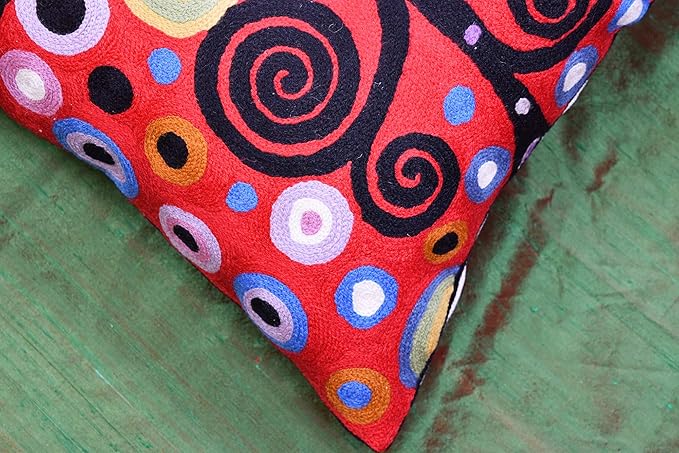 Decorative pillow cover corner in red and black with multicolor swirl circles.