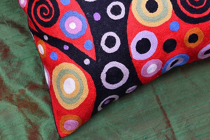 Red and black decorative pillow cover corner with spiral circles and dot accents.