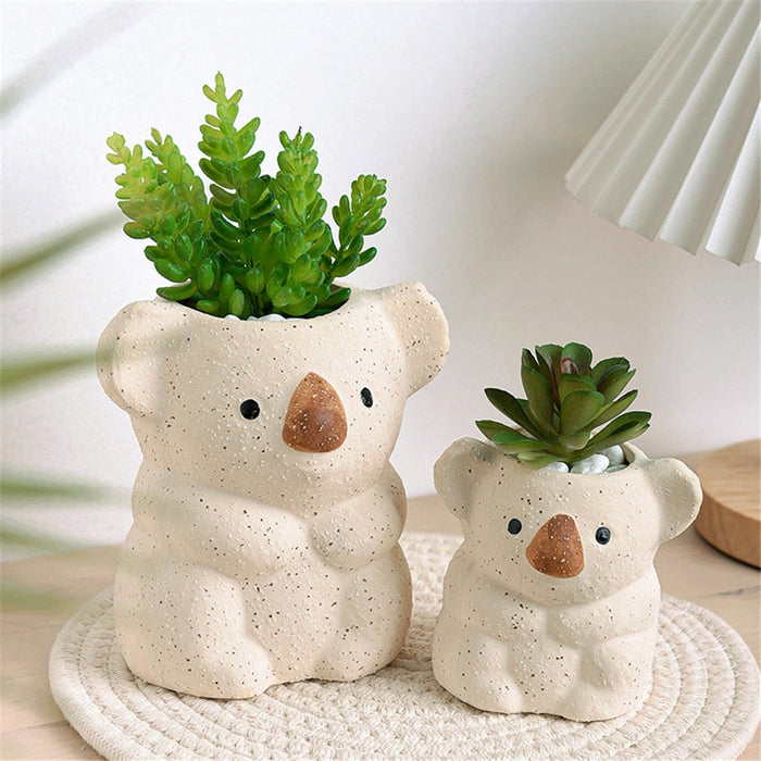 Set of two speckled beige koala planter pots with small succulent plants