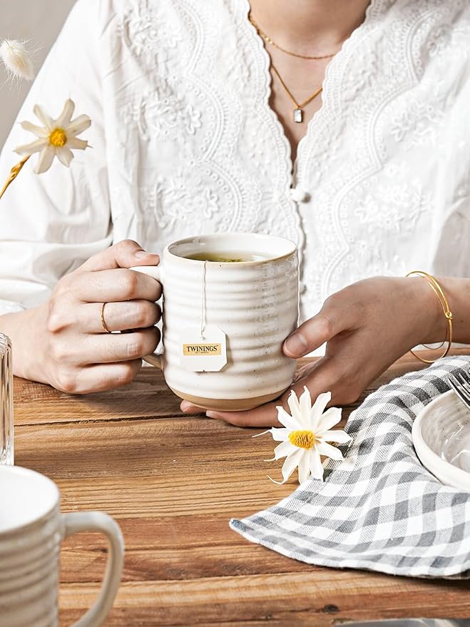 Arctic white ceramic coffee mug with ribbed sides and handle, held at table