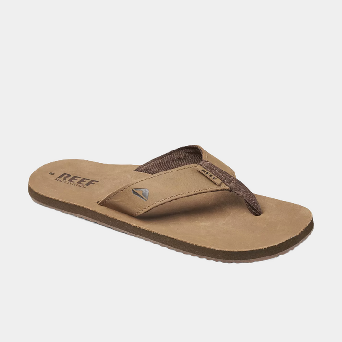 Reef Leather Smoothy Flip Flops in brown with leather upper straps and cushioned footbed, angled side view.