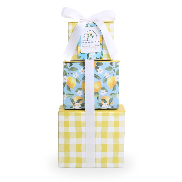 Stacked gift tower boxes with yellow gingham base, blue floral sides, white bow on top