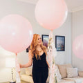 Light pink giant balloon with smaller pink balloons and ribbon ties