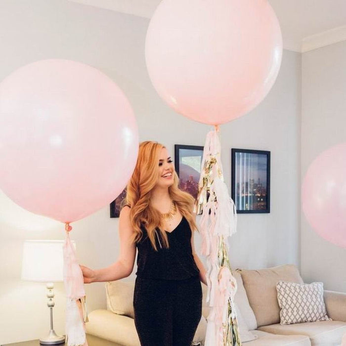 Light pink giant balloon with smaller pink balloons and ribbon ties