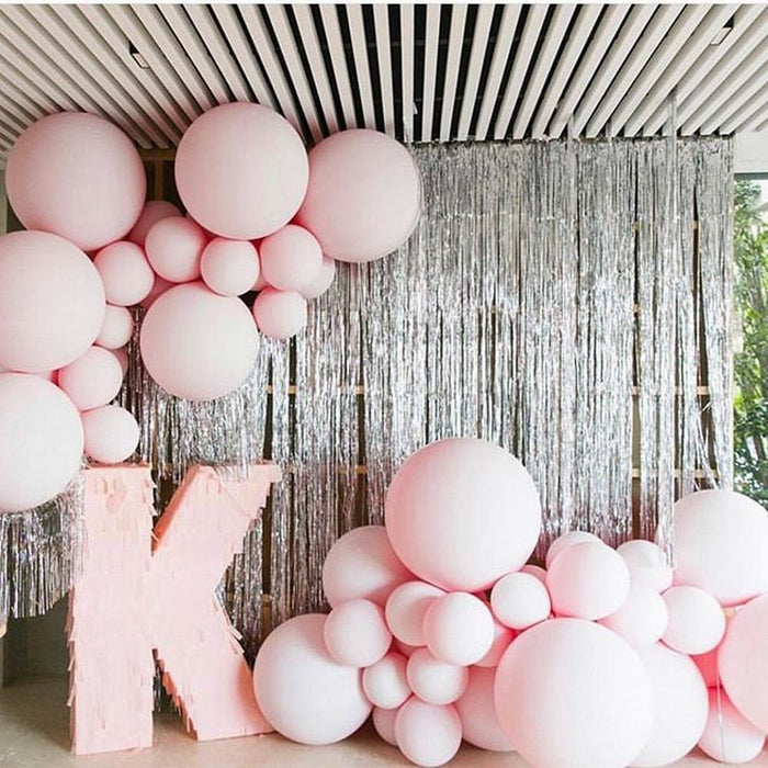 Pink balloon cluster with multiple sizes and a silver fringe backdrop