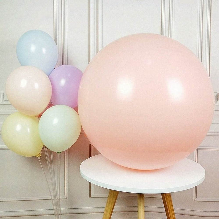 Light pink giant balloon on a round base with pastel balloons behind