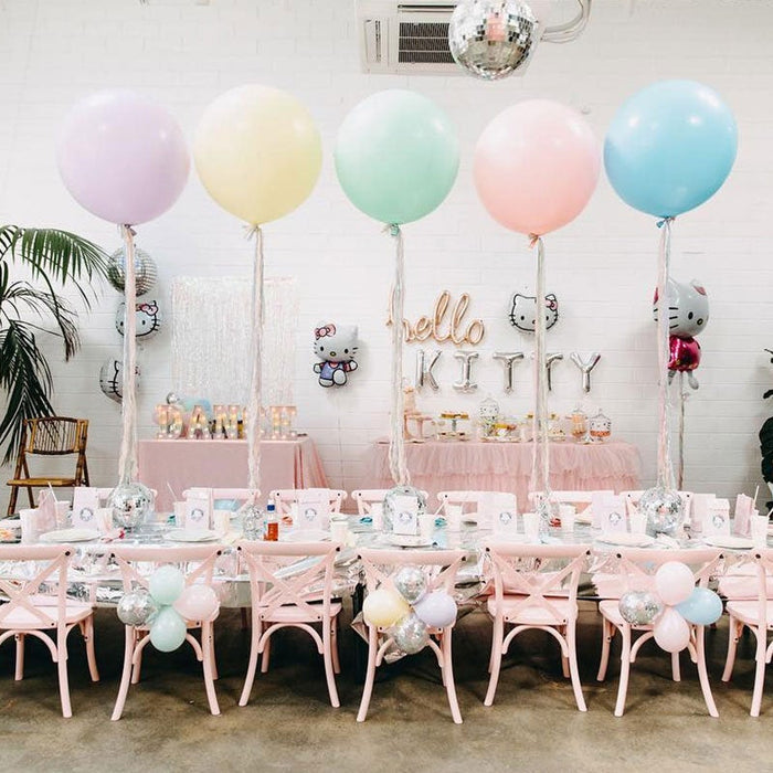 Pastel balloon set with pink, blue, and green balloons above a party table