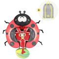 Red ladybug-shaped baby float with black spots, front-facing harness, and a small inset showing a gray drawstring bag with yellow straps.