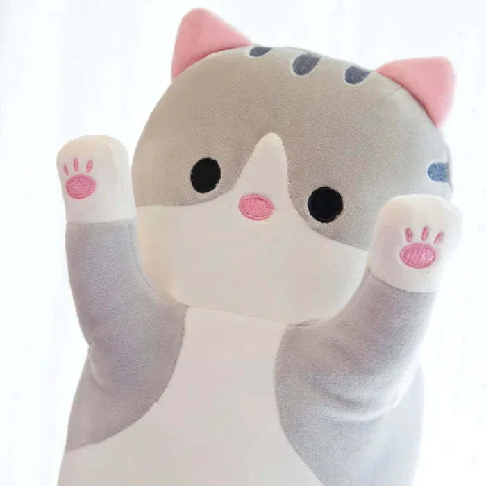 Grey cat plush pillow, white face patch, pink paw pads and nose, soft stuffed design.