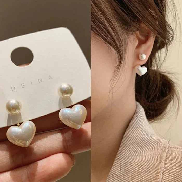 Heart pearl drop earrings with white pearl and glossy heart charm, worn
