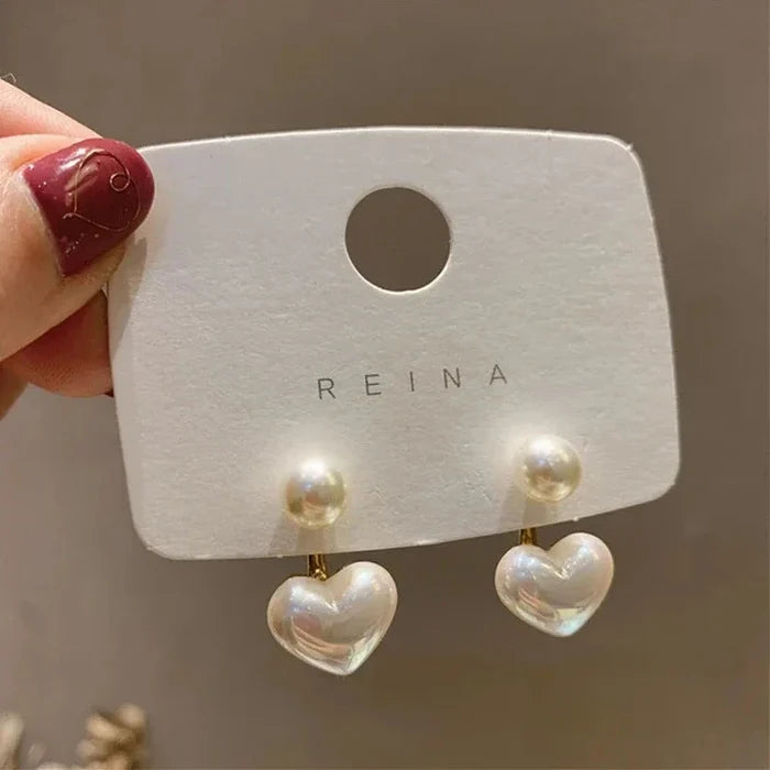 Heart pearl drop earrings on card: white pearl tops with heart-shaped drops