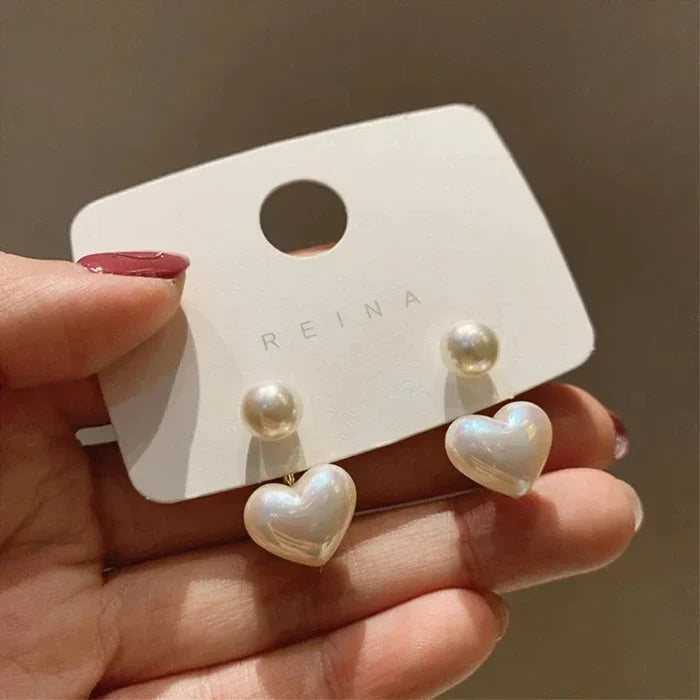Heart pearl drop earrings held on card: white pearl posts with heart dangles