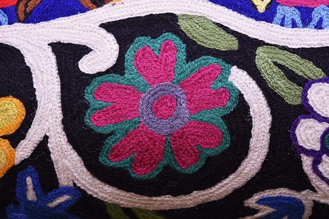Blue embroidered wool lumbar pillow cover close-up of pink and teal flower on dark patch