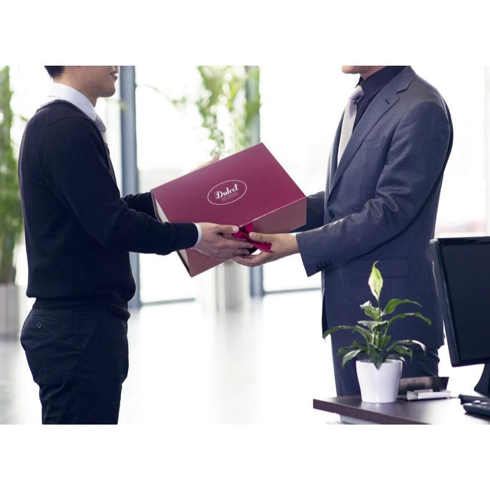Gift box being handed between two people, maroon lid with Dulcet logo