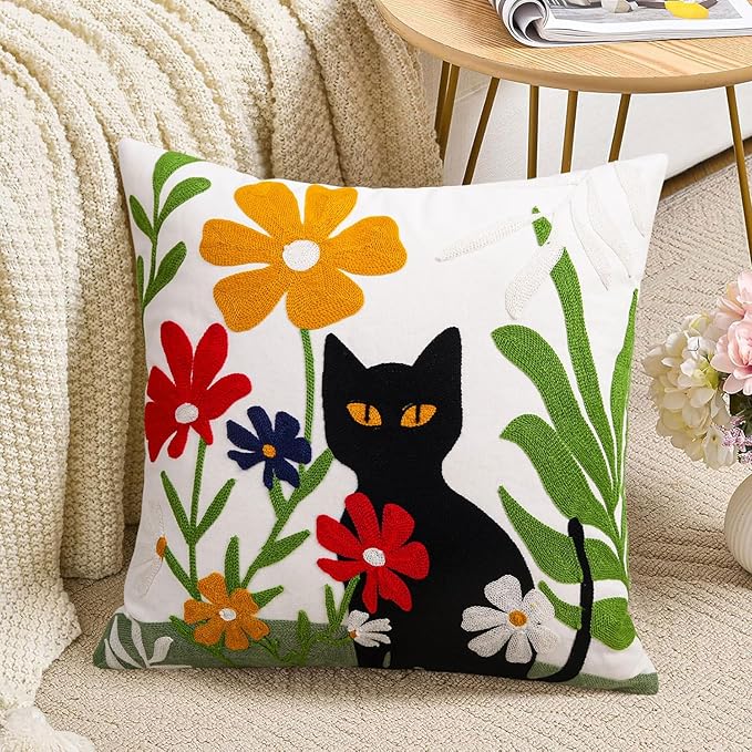 Embroidered pillow cover with black cat silhouette and colorful flowers on white