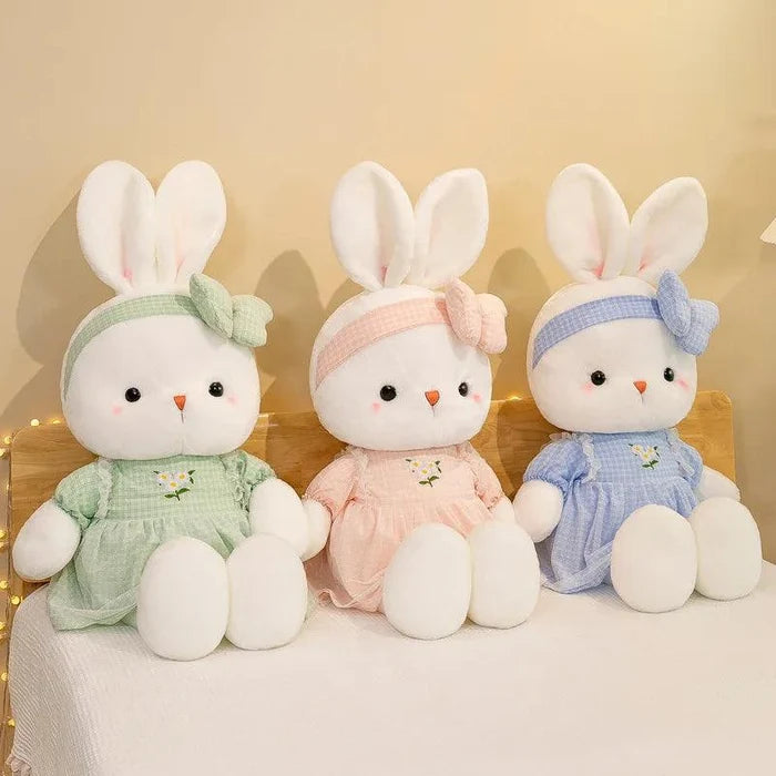 Three bunny plush dolls with pastel green, pink, and blue dresses and bow headbands