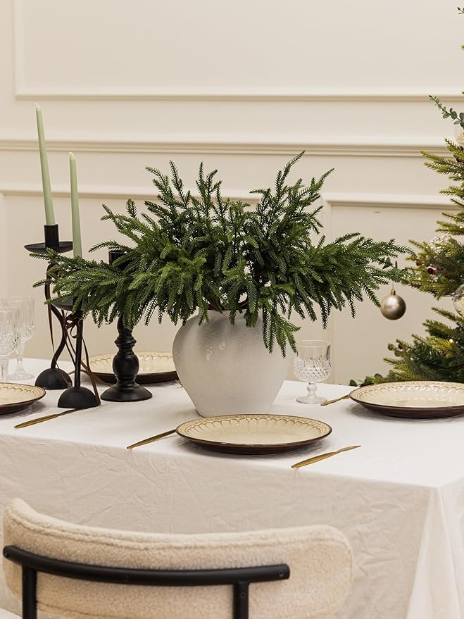 Artificial green pine branch decoration with dense needles in a white pot