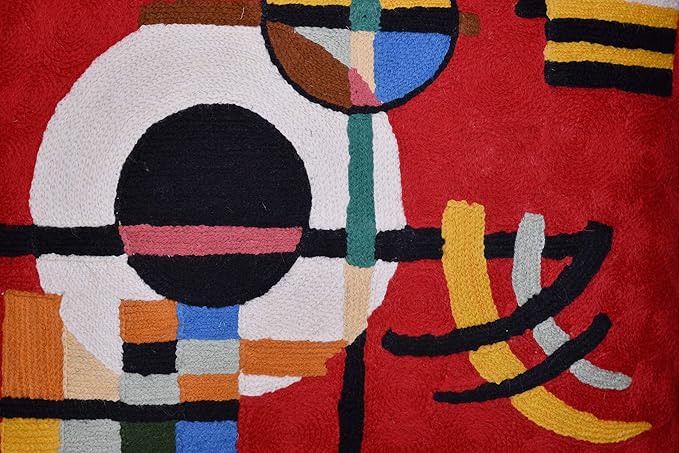 Red abstract embroidered wool pillow cover close-up with circle, stripes, and checker blocks