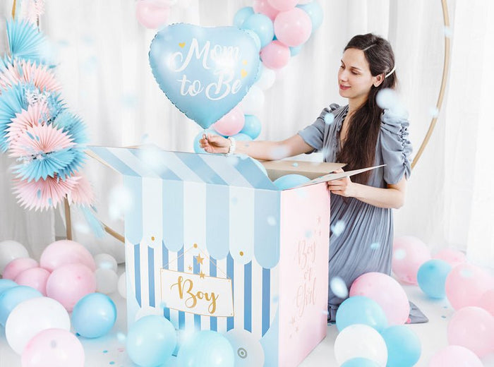 “Mom to Be” heart balloon held by a pregnant woman at a baby shower.