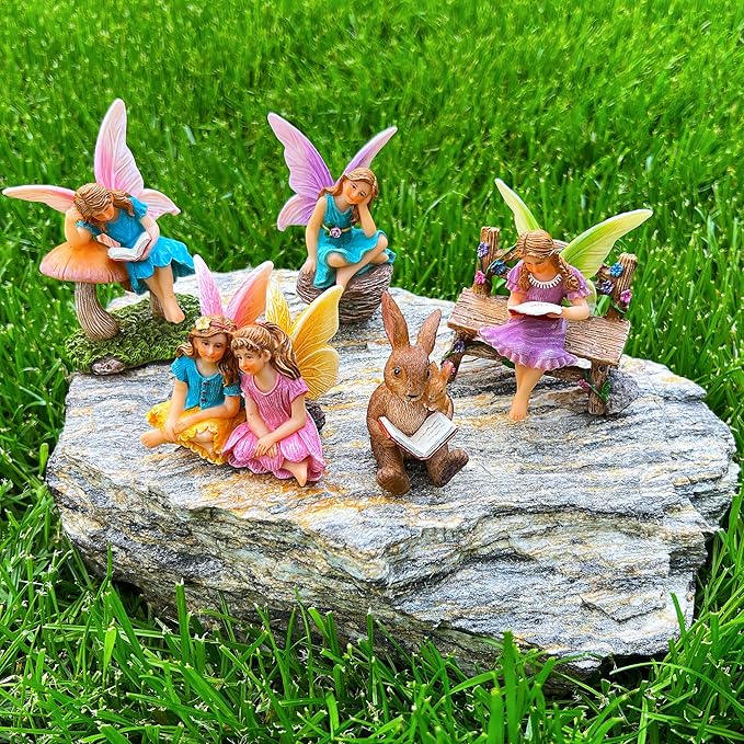 Miniature fairy figurines set on round stone, with bunnies, wings, and tiny reading benches
