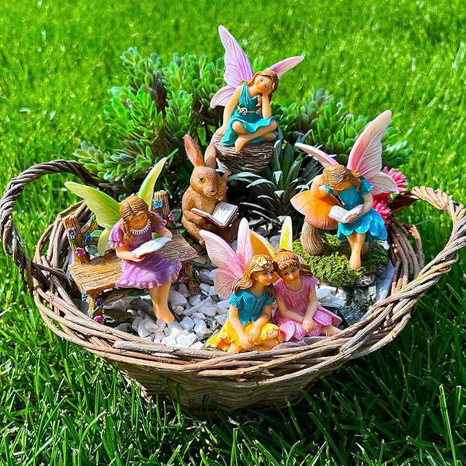 Miniature fairy figurines set in woven basket tray on gravel, several fairies reading and sitting