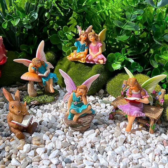 Miniature fairy figurines set with fairies and bunny around a small bench on white gravel