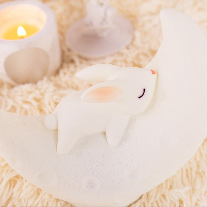 White moon bunny night light speaker close view with warm glowing eye on crescent body