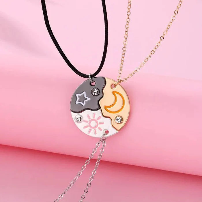 Friendship necklace with dark star-and-sun pendant and gold moon pendant on layered chains
