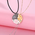 Friendship necklace with dark star-and-sun pendant and gold moon pendant on layered chains